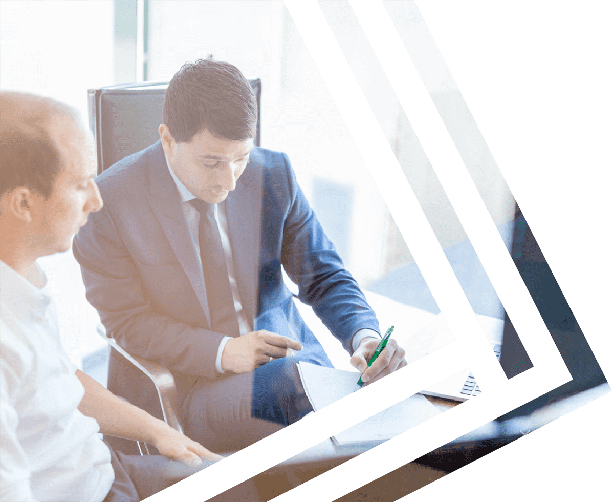Two men writing and talking about business on a desk.